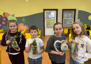 Uczniowie stoją i prezentują swoje lampiony.