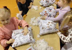 Dzieci z oddziału przedszkolnego ze Szkoły Podstawowej w Rzeczycy wykonują swoje kolorowe, świąteczne poduszki.