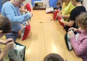 Uczniowie klasy IV, V ze Szkoły Podstawowej w Rzeczycy zaszywają swoje poduszki.