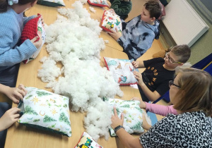 Uczniowie klasy IV, V ze Szkoły Podstawowej w Rzeczycy zaszywają swoje poduszki.