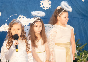 Dziewczynki przebrane za anioły śpiewają.