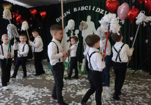 Chłopcy z mopami idą dookoła.