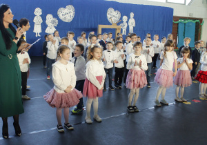 Pani Dyrektor Agata Ewa Ostalska w towarzystwie dzieci z grupy Skoczki i Zuchy wita zaproszonych gości z okazji uroczystości Dnia Babci i Dziadka.