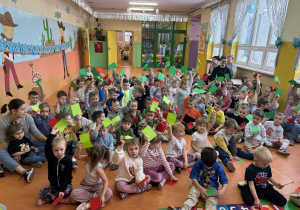 Przedszkolaki unoszą w górze zielone karteczki- rozwiązują quiz dotyczący zasada bezpieczeństwa w ferii zimowych- "Zielone -czerwone" zabawa typu prawda -fałsz.