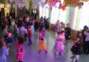 Uczniowie tańczą w rytm muzyki.