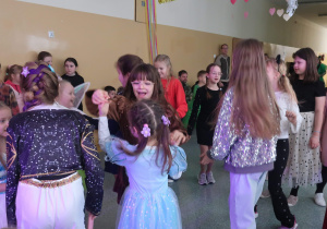 Uczennice tańczące na balu karnawałowym.