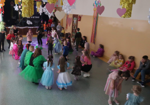 Uczniowie na balu karnawałowym tańczące w rytm muzyki.
