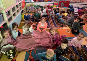 Dzieci z grupy Promyczki słuchają muzyki relaksującej w trakcie leżakowania w Dniu Piżamy.