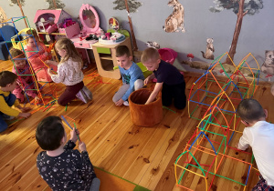 Dzieci z grupy Promyczki budują rakietę i stację kosmiczną z plastikowych słomek w Dniu Piżamy.