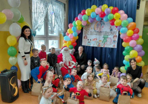 Grupa Promyczki na korytarzu przedszkolnym wraz z Panią Dyrektor, Mikołajem oraz Ciocią Sylwią.