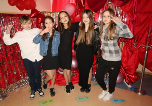 Uczniowie klasy V w dobrych humorach pozują do zdjęcia.