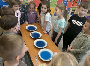 Dzieci z grupy Żabki obserwują galaretki w kolorze niebieskim.