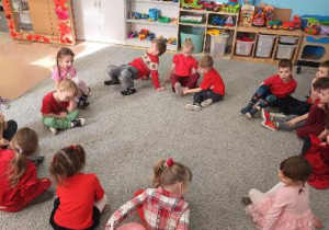 Zabawa w kole w grupie Szkraby - dzieci podają sobie balon w kształcie serca.