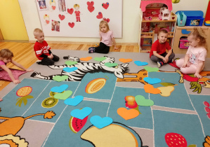 Zabawa dywanowa w grupie Kamyczki - przedszkolaki układają na dywanie serce i kolorowych serduszek.