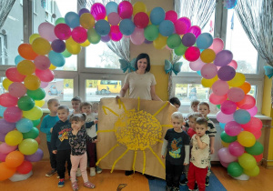 Grupa Kamyczki prezentuje na korytarzu przedszkolnym swoją grupową prace plastyczną - duże żółte słońce.