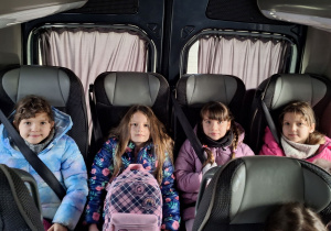 Dziewczyny siedzą wygodnie w fotelach w busie.