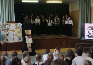 Społeczność uczniowska naszej szkoły oglądająca część artystyczną, w której uczennice przybliżyły życie i twórczość patronki.