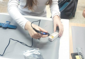 Uczennica czyści lutownicę.