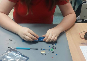 Uczennica montuje elementy.