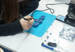 Uczniowie lutują płytki.