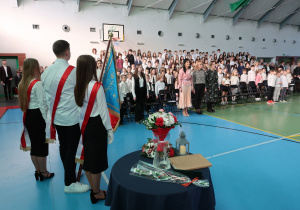 Pani Dyrektor z Gośćmi, Panią Anetą Podlasek i Panią Anną Stańczyk w raz z uczniami śpiewają hymn szkoły, podczas uroczystości obecni są uczniowie z Sztandarem Szkoły.