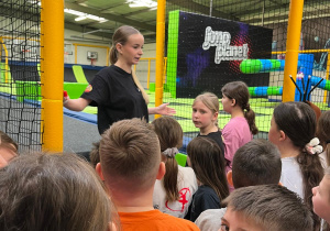 Uczniowie przed wejściem na trampoliny słuchając zasad korzystania z obiektu.