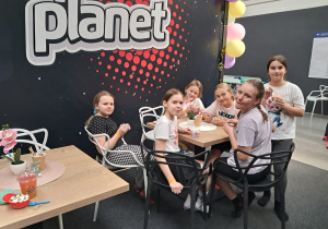 Przerwa od skakania- uczennice siedzą przy stoliku i jedzą lody.