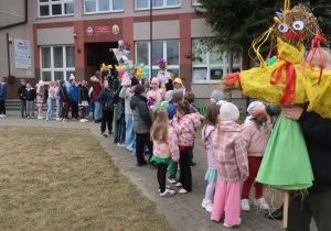 Uczniowie przed szkołą ustawiający się klasami.
