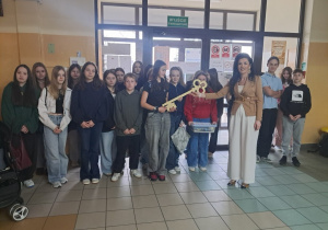 Pani Dyrektor na korytarzu szkolnym wraz z uczniami którzy otrzymali symboliczny klucz na znak że będą prowadzić zajęcia w szkole i przedszkolu.