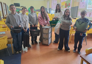 Uczniowie na świetlicy prezentują akcesoria które zastąpiły plecak.