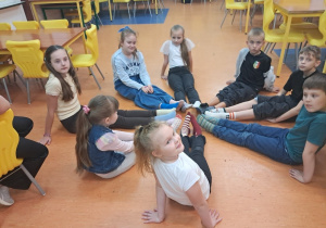 Uczniowie na świetlicy prezentują dwie różne kolorowe skarpetki.