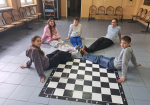 Uczniowie na korytarzu szkolnym świętują dzień kolorowej skarpetki.