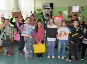 Uczniowie klasy trzeciej z nietypowymi przedmiotami zamiast plecaka.