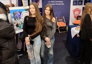 Uczennice klasy 8b na tle stoiska II LO w Tomaszowie Maz.