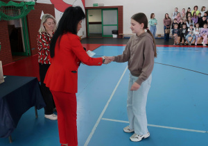 Pani Dyrektor, wręcza nagrody i dyplomy uczniom podczas apelu.