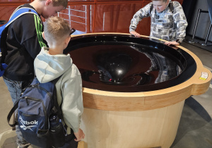 Grupa chłopców samodzielnie obserwuje zjawiska naukowe.