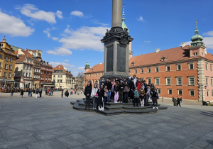 Grupa uczniów przy Kolumnie Zygmunta III Wazy na placu zamkowym w Warszawie.