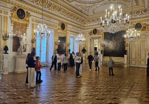 Uczniowie zwiedzają Zamek Królewski w Warszawie z audiobookami.