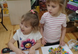 Kamyczki wykonują prace plastyczną Kolorowy motyl.