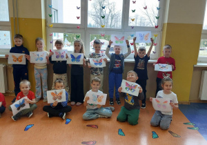 Dzieci z grupy Zuch prezentują wykonane przez siebie motylki.
