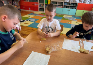 Chłopcy rozpakowują torebki z kruchymi ciasteczkami.