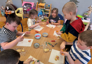 Dzieci z grupy Promyczki dekorują ciasteczka lukrowymi mazakami oraz cukrowymi posypkami.
