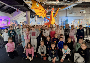 Wspólne zdjęcie uczniów przed smokiem wykonanym z klocków lego.