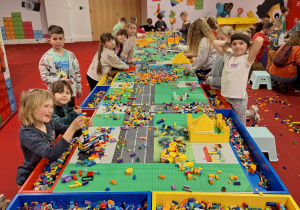 Pierwszoklasiści konstruują swoje budowle z klocków Lego.