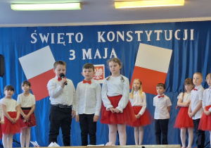 Uczniowie klasy pierwszej recytują wiersze patriotyczne.