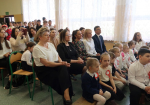 Zaproszeni goście, rodzice i społeczność szkolna podczas akademii.