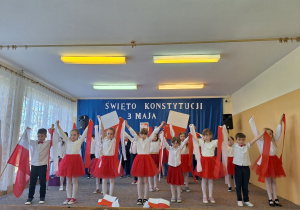 Chłopcy i dziewczynki tańczą przy piosence ,,Płynie Wisła płynie‘’.