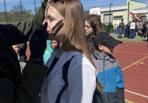 Zadowoleni uczniowie malują twarze.