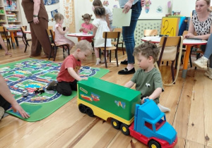 Chłopy bawią się dużym autem.